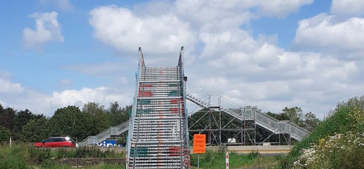 steile brug van steigerdelen met bord 'fietsers afstappen, fiets aan de hand'.